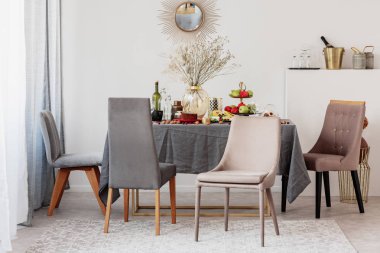 Zarif yemek odası iç süslü ayna ile masada şık sandalyeler