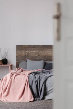 Pastel pembe ve gri battaniye king size Yataklı Ahşap karyola ile gri yatak var