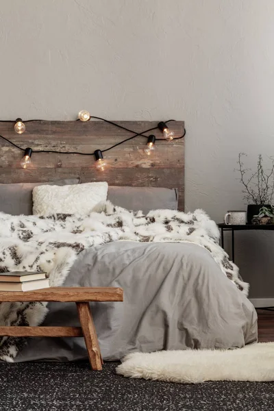 キングサイズ ベッド木製のヘッドボードとライトの灰色の寝具に白い伝説毛布 — ストック写真