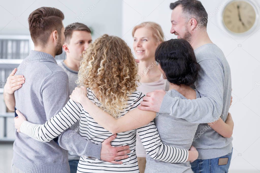 Men and women hugging each other and supporting during psychotherapy