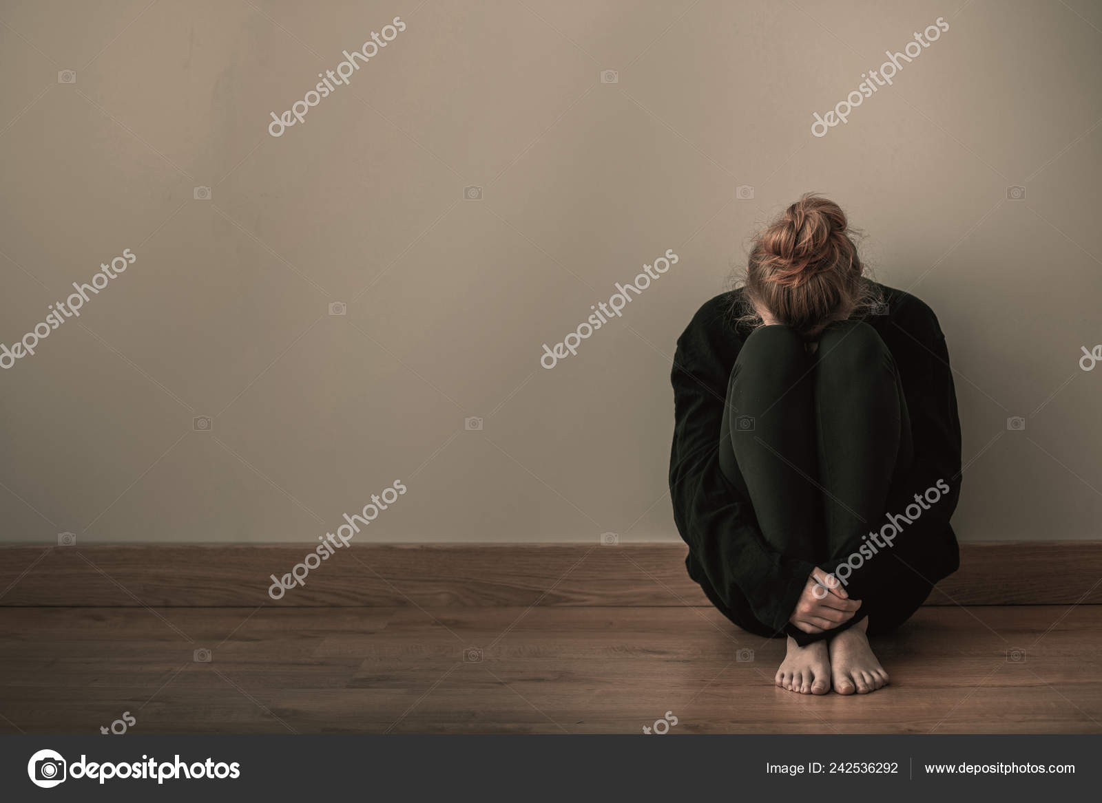 悲伤的少女蜷缩在地板上复制空墙上的空间——图库图片© photographee.eu #242536292