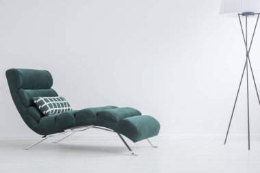 Damalı yastık yanındaki kopya alanı boş duvar ile düzgün oturma odasında trendy lamba ile modaya karanlık yeşil kanepe