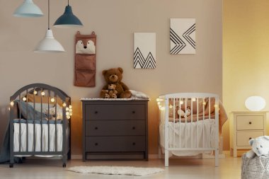 Beyaz ve gri beşik ile sıcak bebek yatak odası iç, komodin ve lamba ile küçük gece standı masası