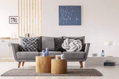 Mavi soyut boyama beyaz duvar üzerinde modern oturma odası iç yastık ile gri set tee