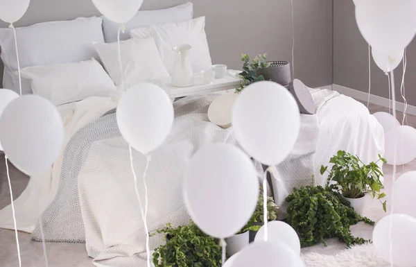 城市丛林和一堆白色气球在时尚的卧室与白色床上用品和灰色毯子的特大号床 — 图库照片