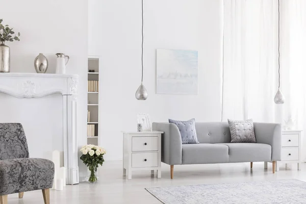 灰色的躺椅上的枕头 位于白色的客厅内部 花靠近图案扶手椅 真实照片 — 图库照片