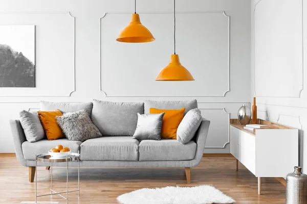 Zwei Orangefarbene Lampen Über Grauer Skandinavischer Couch Mit Kissen — Stockfoto