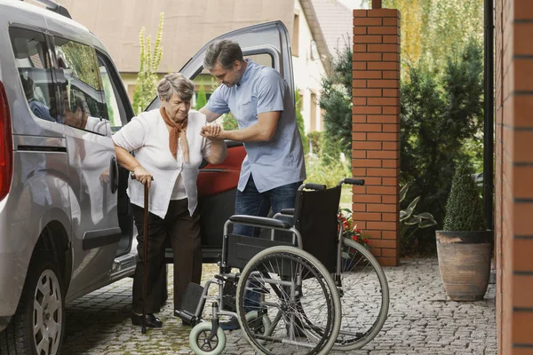 Starsza Kobieta Wychodzi Samochodu Pomocą Pielęgniarki — Zdjęcie stockowe