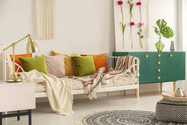 橄榄绿色, 柔和的粉红色, 黄色和橙色枕头在单金属床与图案床上用品在 boho 卧室内部的女孩 — 图库照片
