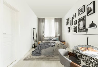 Beyaz duvar ile parlak yatak odası iç titriyordu masa örtüsü ile tablo