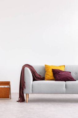 Duvarda kopya alanı ile beyaz minimal oturma odası iç yastıklar ile gri kanepe. Gerçek fotoğraf