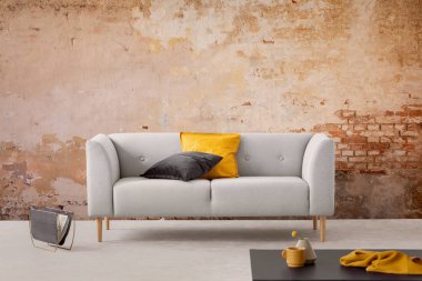 Siyah tablo ve gri kanepe yastıkları basit salon iç ile kırmızı tuğla duvar ile. Gerçek fotoğraf