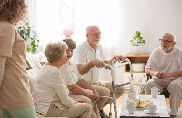 Skupina seniorů s rozhovorem v pečovatelské domácnosti — Stock fotografie
