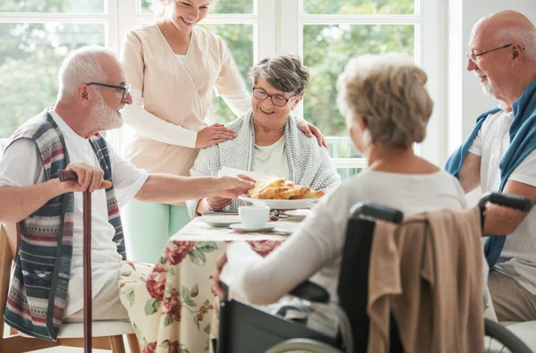 Lyckliga seniorer som har en tårta på ett vård hem — Stockfoto