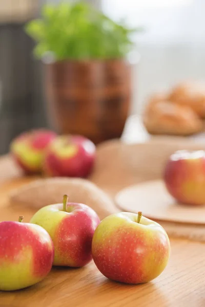 Nahaufnahme auf roten und grünen Äpfeln auf einem Holztisch im Speisesaal mit gesundem Essen. echtes Foto — Stockfoto