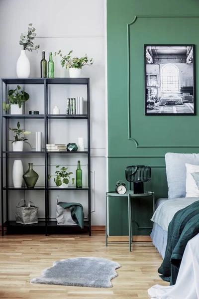 Rak buku hitam dengan tanaman di sudut kamar tidur yang indah dengan dinding hijau — Stok Foto
