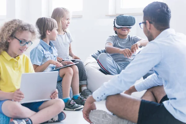 Garoto fascinado usa óculos de realidade virtual durante aula de tecnologia para crianças na escola inovadora — Fotografia de Stock