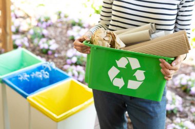 Cropped view of eco friendly woman holding green recycling box with paper waste clipart