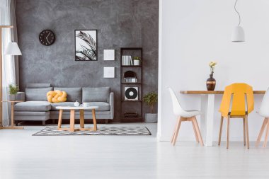 Gri ve beyaz çağdaş yemek ve ahşap masa moda sandalye ve gri sarı düğüm yastık kanepeyle yatak odası