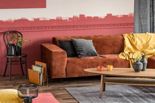 Stylish coffee table in front of brown velvet corner sofa in living room with ombre wall — Stock Photo, Image