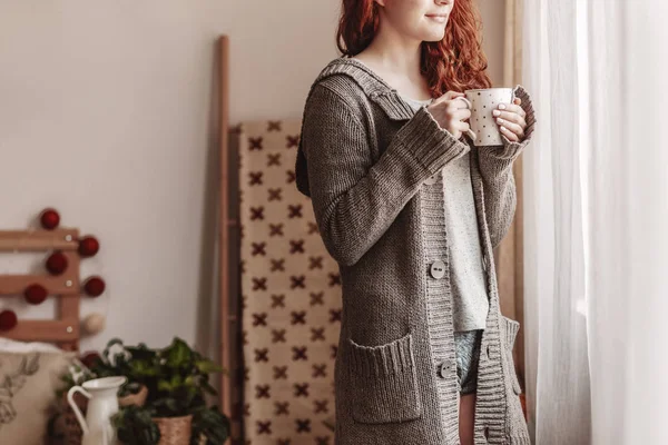 Femme portant un pull et buvant du thé chaud à l'intérieur de la chambre à coucher pendant l'automne — Photo