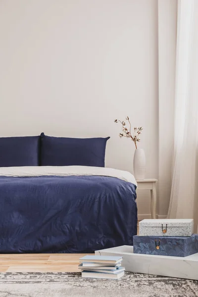 Stapel boeken op tapijt van modieuze slaapkamer interieur met kingsize bed en kopie ruimte — Stockfoto