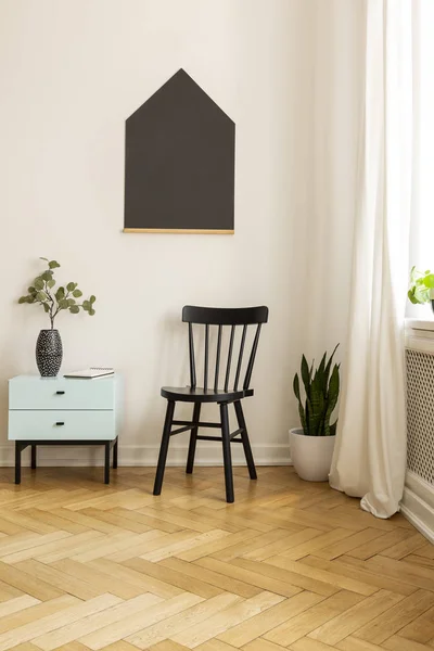 Cabinet next to black chair in minimal room interior with poster and plant on wooden floor. Real photo — Stock Photo, Image