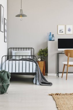 Şık gri yatak odasında mavi yatak ile tek endüstriyel yatak, boş duvara kopya alanı