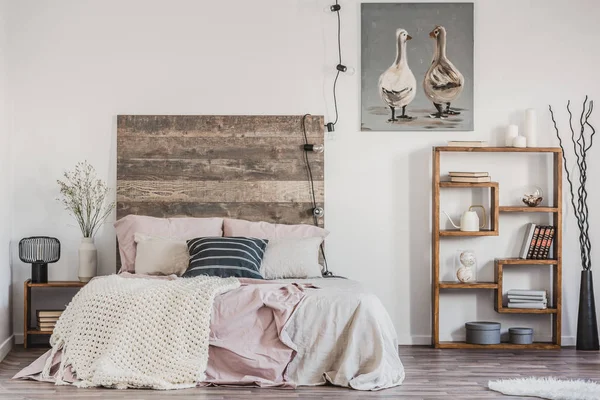 Schattige poster met twee eenden op witte muur van smaakvolle slaapkamer interieur met bed met pastel roze beddengoed — Stockfoto