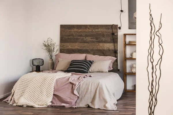 Черно-белая подушка на пастельно-розовых и бежевых постельных принадлежностях — стоковое фото
