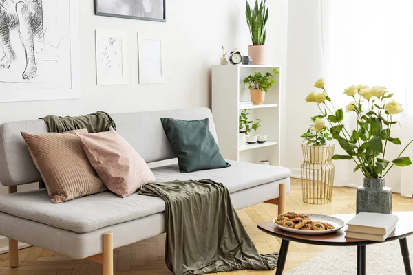 White roses in vase, cookies on the plate and books on wooden coffee table in fashionable living room in tenement house — Stock Photo, Image