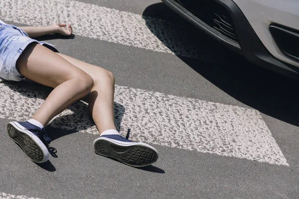 Victim of a traffic accident on pedestrian crossing next to a car — Stock Photo, Image