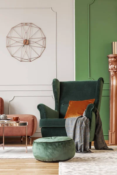 Poltrona verde elegante com travesseiro laranja escuro e cobertor cinza no interior da sala de estar elegante com design moderno — Fotografia de Stock
