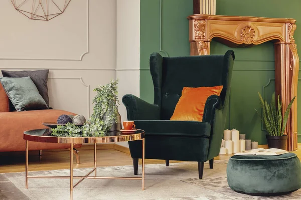 Bequemer smaragdgrüner Sessel mit orangefarbenem Kissen im trendigen Wohnzimmer-Interieur — Stockfoto