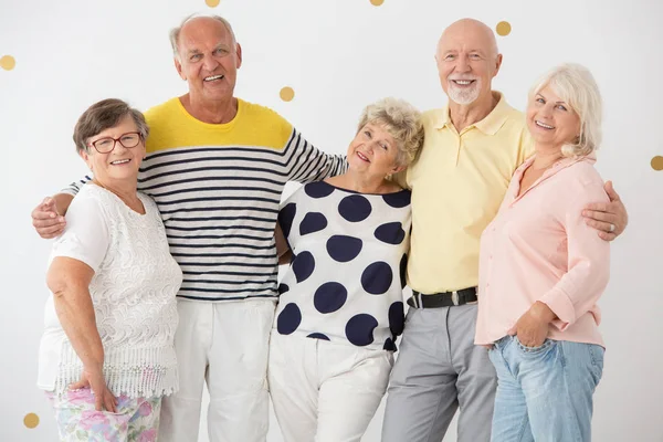 Группа счастливых старших друзей стоят вместе и улыбаются — стоковое фото