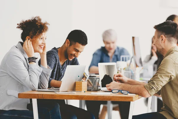 Glückliche junge Unternehmerin mit Praktikanten, die gemeinsam auf Freiflächen in multikulturellen Unternehmen arbeiten — Stockfoto