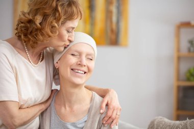 Yaşlı Redhead kadın kemik tümörü muzdarip mutlu lezbiyen ortağı alnını öpüyor