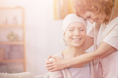 Bright photo of positive redhead woman hugging her sick partner who is suffering from lung cancer clipart