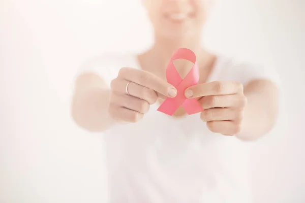 Brillante foto de una joven sosteniendo cinta rosa como un canto de apoyo para las mujeres con cáncer de mama — Foto de Stock