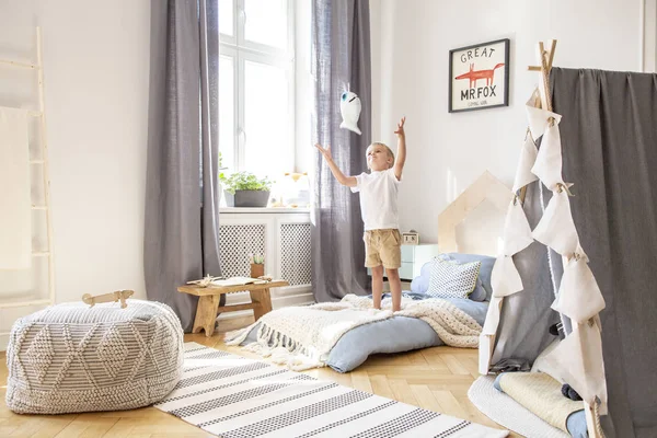 Jongen spelen met een speeltje in een gezellig kind speelkamer interieur — Stockfoto