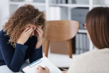 Üzgün kadın kişisel terapist ile Toplantı sırasında yüzünü gizlemek