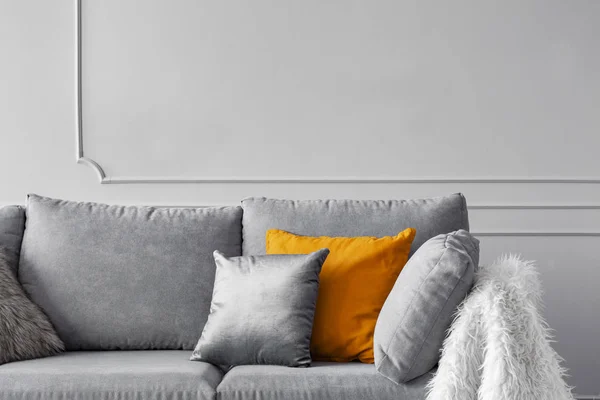 Zilveren, oranje en grijze kussens op comfortabele sofa — Stockfoto