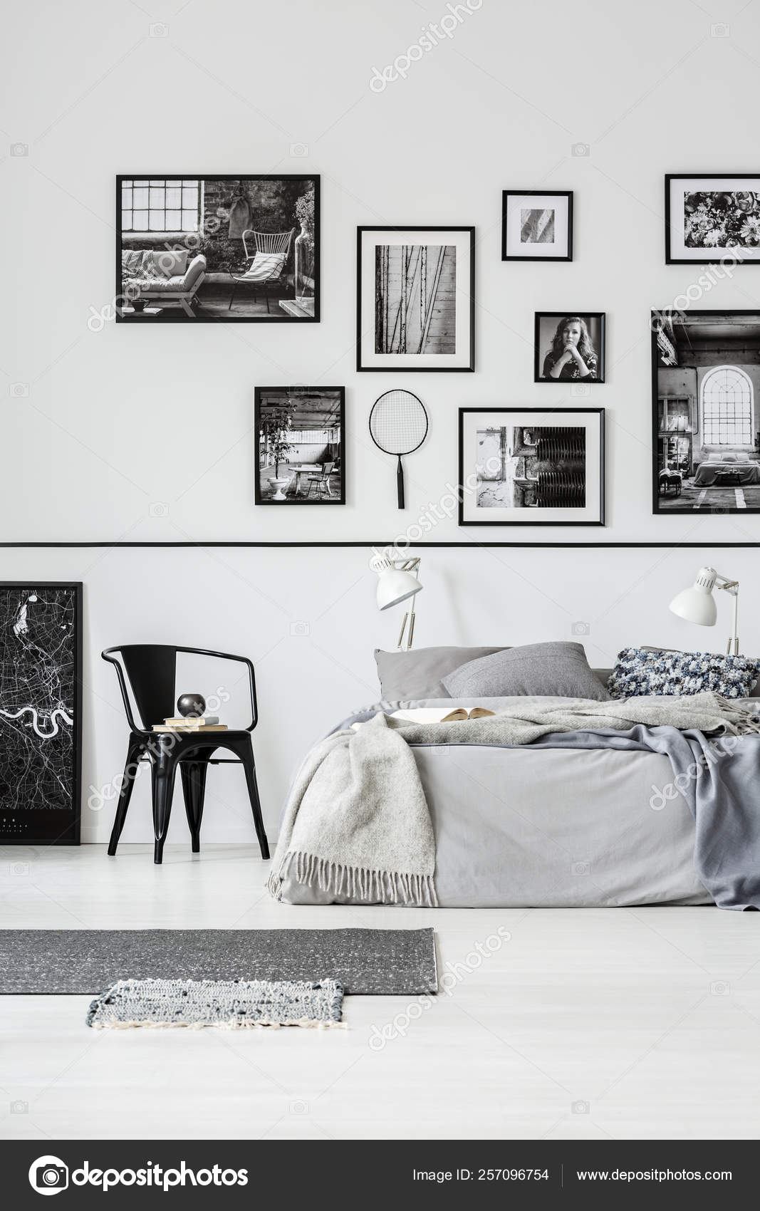 Rugs And Black Chair Next To Bed In White Bedroom Interior