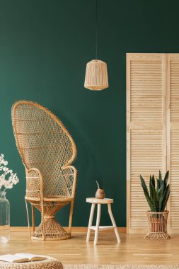 Lamba üzerinde tablo ve rattan sandalye çiçekler ve ekran ile yeşil daire iç. Gerçek fotoğraf