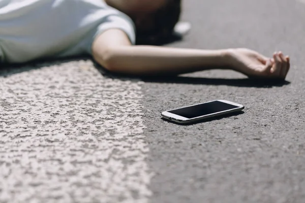 Smartfon na przejściu przez pieszych po wypadku drogowym z osobą — Zdjęcie stockowe