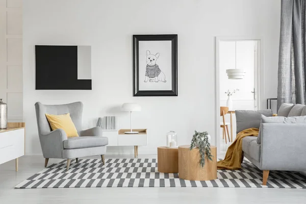 Cómodo sillón gris en elegante salón interior con muebles blancos y dos mesas de centro de madera — Foto de Stock