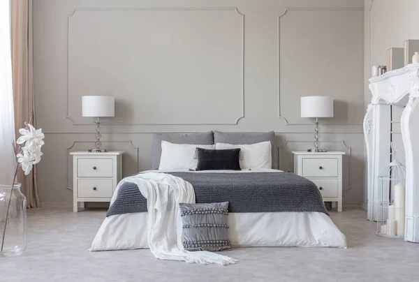 King size bed met grijze en witte lakens tussen twee houten nachtkastjes met stijlvolle New Yorkse lampen — Stockfoto