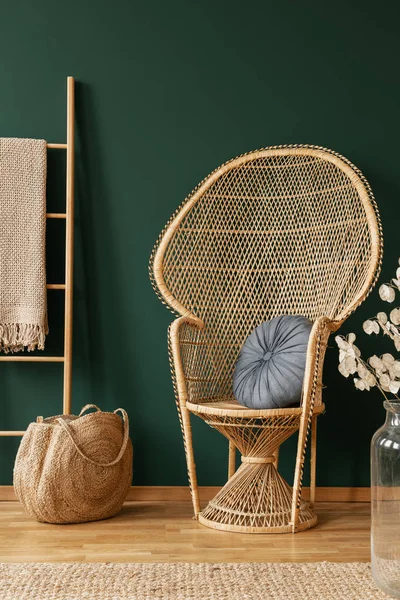 Cadeira de vime ao lado de saco e escada em verde sala de estar interior com flores e tapete. Foto real — Fotografia de Stock