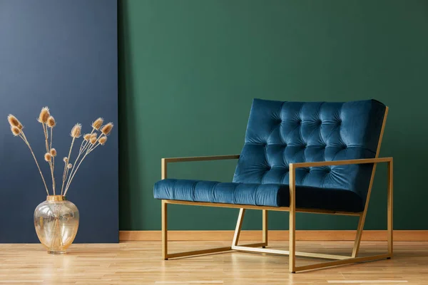 Plant in gold vase next to armchair in blue and green elegant living room interior. Real photo — Stock Photo, Image