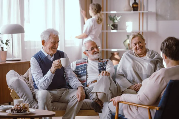 Personas mayores sonrientes hablando juntas en un asilo de ancianos —  Fotos de Stock